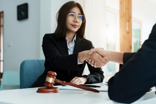 Law, consultation, agreement, contract, lawyer or attorney shakes hands to agree on the client's offer to be hired to fight the parties in court