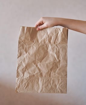 Girl holds an eco-friendly paper bag. Close-up. Shopping bag
