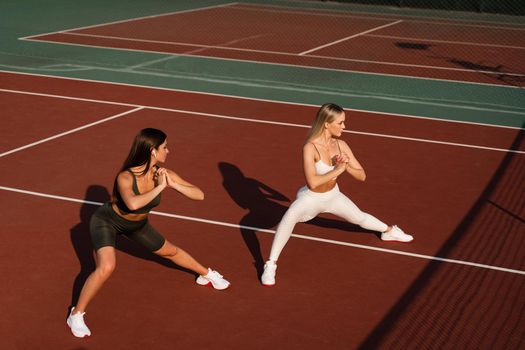 Group stretching of 2 fit girls. Active sport lifestyle. Outdoor training.