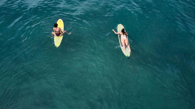 Aerial view of the ocean and surfer girls. Surfing in Midigama. Sri Lanka