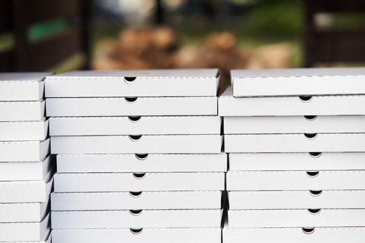 Stack of white cardboard pizza packages. Pizza packages close-up. High-quality photo