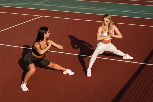 Group stretching of 2 fit girls. Active sport lifestyle. Outdoor training.