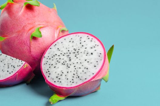 The Halves of Fresh organic Dragon Fruit on a blue background.