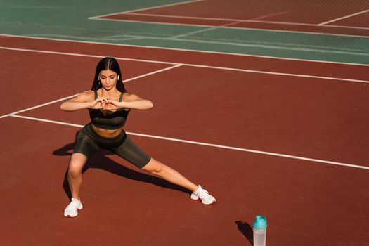 Fit girl does warm-up and stretching exercises before a street workout. Sports lifestyle