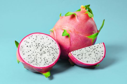The Halves of Fresh organic Dragon Fruit on a blue background.