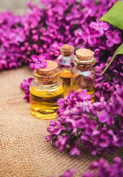 Lilac essential oil in a small bottle. Selective focus. Nature.