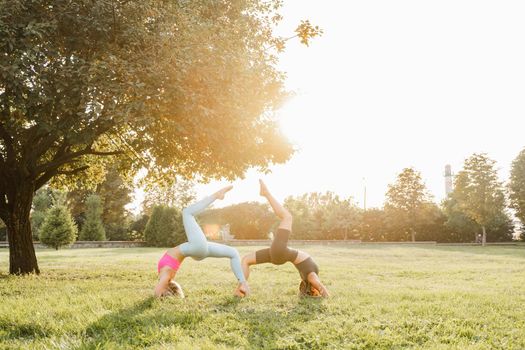 2 girl doing outdoor sport training and yoga in the park