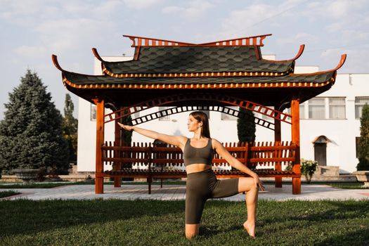 Meditation and relaxation outdoor. Asiat fir girl is meditating near chinese gazebo