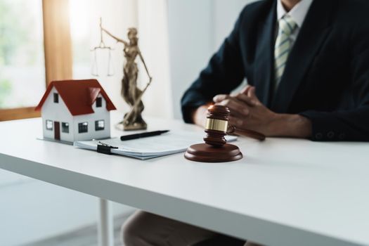 Law, Consultation, Agreement, Contract, Concept Attorney or lawyer focusing on the court hammer is sitting on the chair with a client's complaint to determine the house and land in court.