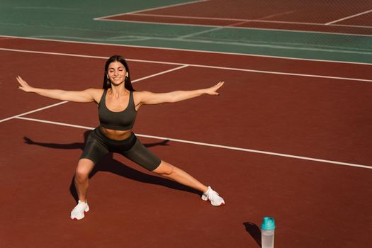 Fit girl does warm-up and stretching exercises before a street workout. Sports lifestyle