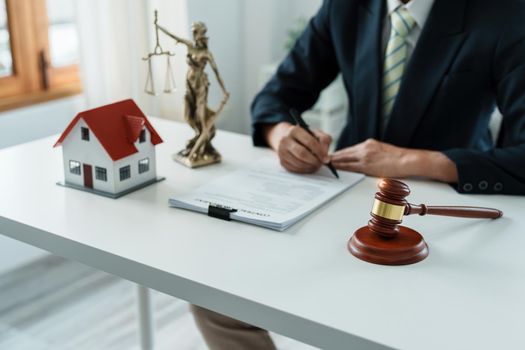 Law, Consultation, Agreement, Contract, Concept Attorney or lawyer focusing on the court hammer is sitting on the chair with a client's complaint to determine the house and land in court.