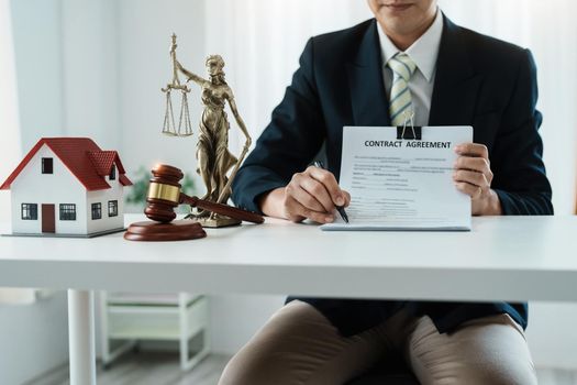 Law, Consultation, Agreement, Contract, Concept Attorney or lawyer holding pen pointing document is sitting on the chair with a client's complaint to determine the house and land in court.