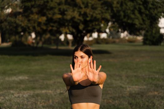 Hand movement of qigong meditation. Attractive girl meditating in the green park