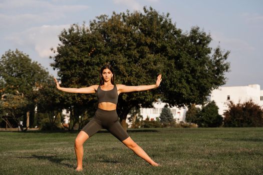 Hand movement of qigong meditation. Attractive girl meditating in the green park