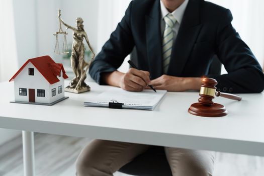 Law, Consultation, Agreement, Contract, Concept Attorney or lawyer focusing on the court hammer is sitting on the chair with a client's complaint to determine the house and land in court.