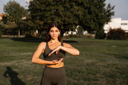 Hand movement of qigong meditation. Attractive girl meditating in the green park