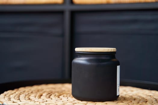 Stylish black jar with a wooden lid for a candle or cream. High quality photo