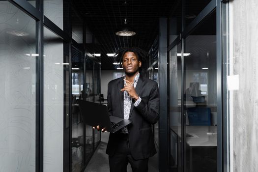 Black man freelancer with laptop in coworking space. Online working on laptop