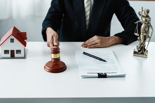 Law, Consultation, Agreement, Contract, Concept Attorney or lawyer focusing on the court hammer is sitting on the chair with a client's complaint to determine the house and land in court.