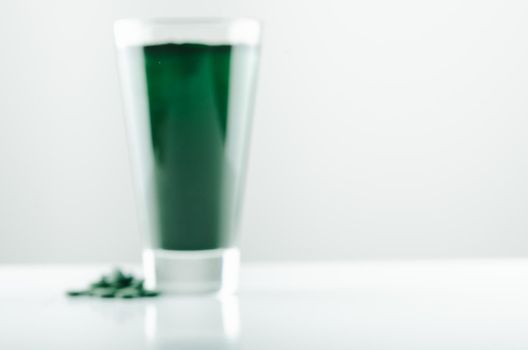 minimalist glass with water and spirulina powder. High quality photo