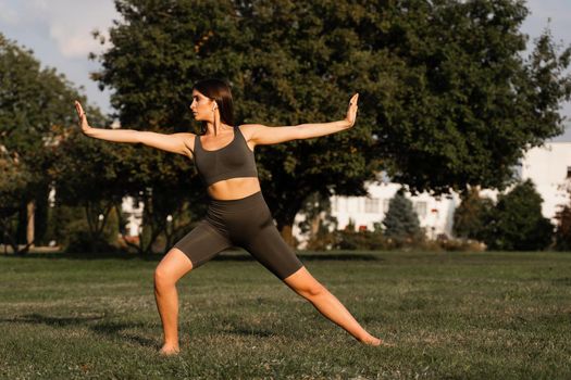 Hand movement of qigong meditation. Attractive girl meditating in the green park