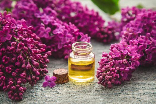 Lilac essential oil in a small bottle. Selective focus. Nature.