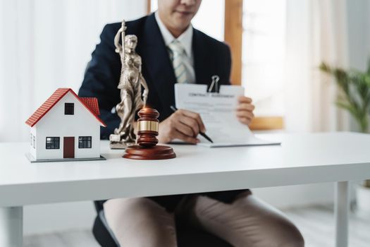 Law, Consultation, Agreement, Contract, Concept Attorney or lawyer focusing on the court hammer is sitting on the chair with a client's complaint to determine the house and land in court.