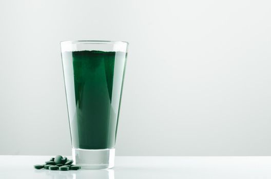 minimalist glass with water and spirulina powder. High quality photo