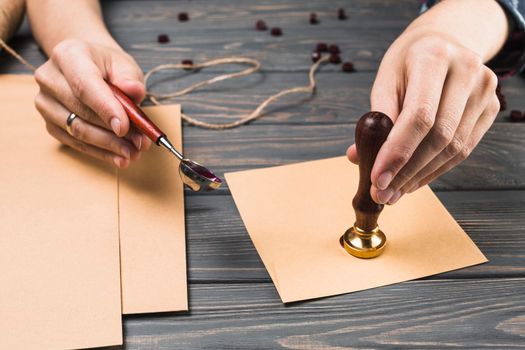 woman s hand sealing envelope with stamp