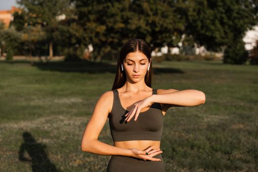 Hand movement of qigong meditation. Attractive girl meditating in the green park