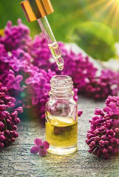 Lilac essential oil in a small bottle. Selective focus. Nature.