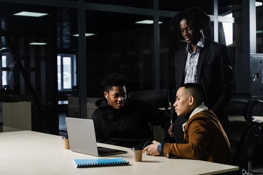 Multinational brainstorm group of colleagues working online on project in briefing room. Black african business man and asian work in team together