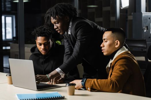 Mixed race of men teamwork on laptop in office. Discussing and working on on online projects