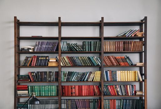 Bookcase with old books on the shelves. Books in an old wooden Cabinet