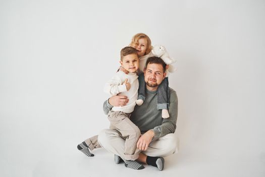 Happy family. Father, daughter and son hugging and smiling on white background. Paternity. Single father bring up his children