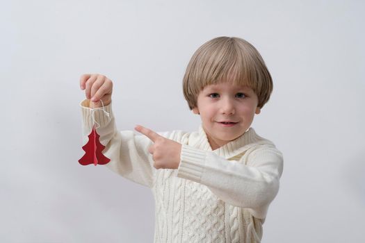 Child holding Christmas gift box in hand. Boy Isolated on white background. New year and x-mas concept.