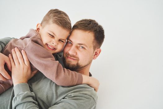 Close-up portrait of smiling father and son. Handsome dad and cheerful and emotional kid. Paternity