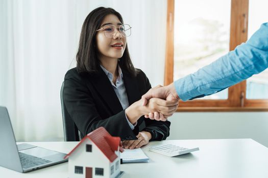 Laws, contracts, mortgages, clients join hands with real estate agents congratulating real estate agents on home and land purchase agreements with insurance to reduce risks during home installments.