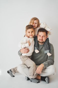 Happy family. Father, daughter and son hugging and smiling on white background. Paternity. Single father bring up his children