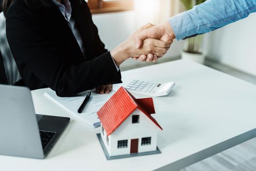 Laws, contracts, mortgages, clients join hands with real estate agents congratulating real estate agents on home and land purchase agreements with insurance to reduce risks during home installments.