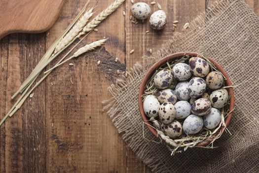 Quail eggs in a bowl top view on a wooden table