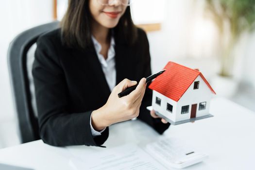 Law, agreement, contract, mortgage, woman holding a pen, pointing at a house to see the interest rate and asking for the limit to assess the risk before buying a house.