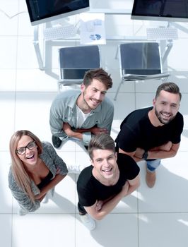 young businesspeople looking up with arms crossed at the waist