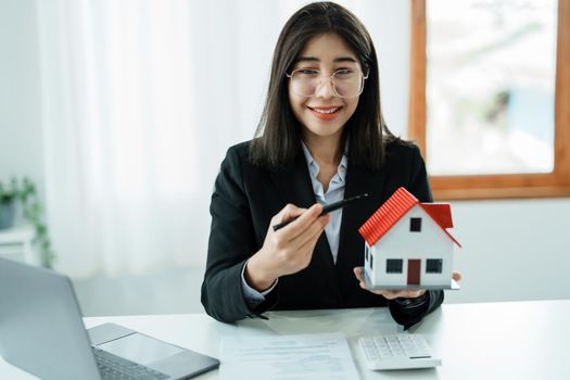 Law, agreement, contract, mortgage, woman holding a pen, pointing at a house to see the interest rate and asking for the limit to assess the risk before buying a house.