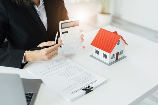 Entrepreneurs, business owners, accountants, real estate agents, A young woman uses a calculator to calculate her home budget to assess the risks of investing in real estate