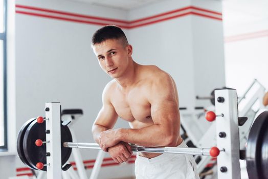 Beautiful man with big muscles, posing for the camera in a nice bright room gym. Sport. Fitness