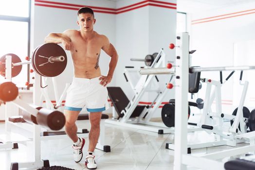Beautiful man with big muscles, posing for the camera at the gym.