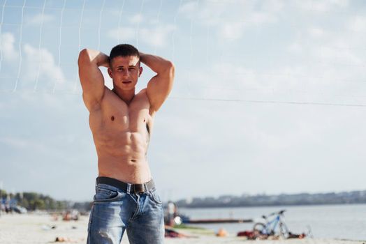 muscular male model with perfect body posing in blue jeans.