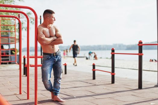 Strong young athlete engaged on the playground. Exercises on the bars outdoors. Fitness. Sport. Exercises.