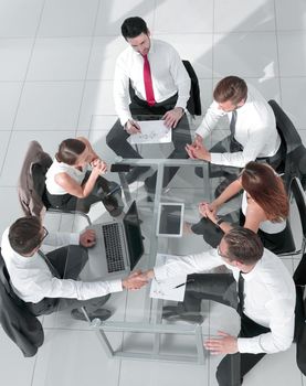 Office workers gather around a table to do research and implement new ideas.